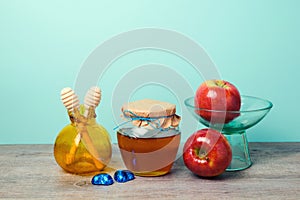 Honey jar, apples and pomegranate vase on wooden table. Jewish holiday Rosh Hashana celebration