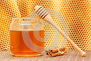 Honey in jar with dipper, cinnamon and honeycomb o