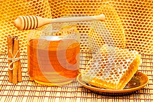 Honey in jar with dipper, honeycomb and cinnamon o