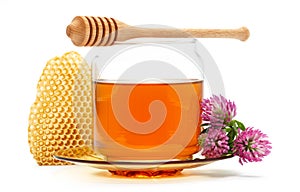 Honey in jar with dipper, honeycomb, flower on isolated background