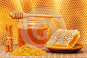 Honey in jar with dipper, honeycomb, pollen and ci