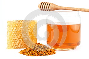 Honey in jar with dipper, honeycomb, pollen on isolated background