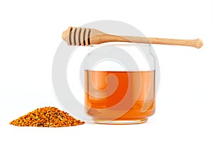 Honey in jar with dipper and pollen on isolated background