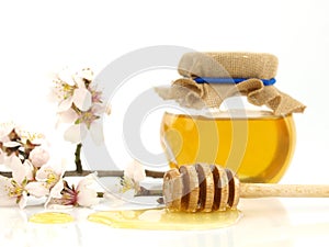 Honey in a jar, flowers and honey dipper