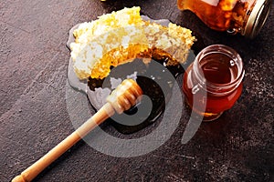 Honey in jar with honey dipper on vintage rustic background