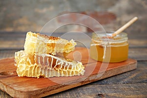 Honey in a jar and honeycomb on an old wooden background