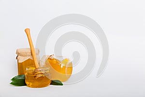 Honey in jar with leaves and honey dipper on colored background top view with copy text