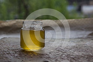 Honey in jar and window with green on backcground