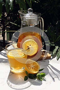 Honey lemon drink in a transparent glass and jar.
