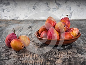 Honey plums are lined with a slide on a clay plate on a gray background