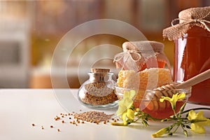 Honey pots honeycomb and bee pollen on white kitchen table