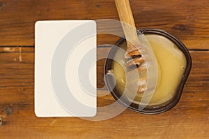 honey pour from a wooden spoon into a clay plate
