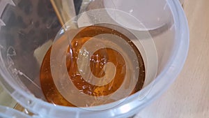 Honey is poured into a container. Beautiful honey. Container with honey.