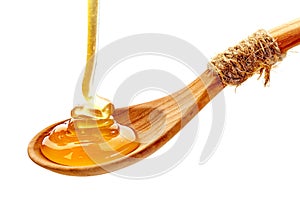 Honey pouring into wooden spoon