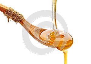 Honey pouring into wooden spoon