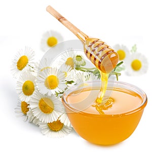 Honey pours with sticks in a jar.