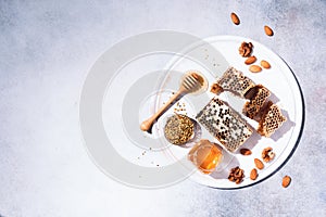 Honey products background. Honeycomb frame, bee pollen granules, honey in glass pot, almond nuts on grey concrete background. Copy