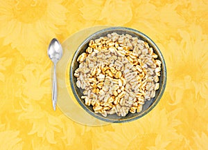 Honey puffed wheat in a bowl with spoon to the side