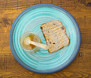 Honey with stick pouring over toast bread