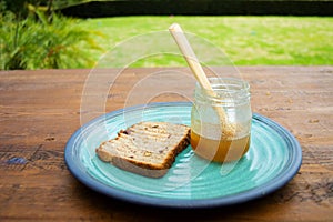 Honey with stick pouring over toast bread
