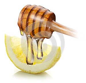 Honey with wood stick pouring onto a slice of lemon.