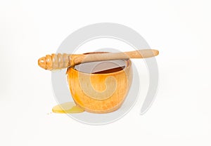 Honey in a wooden bowl, and a honey dipper.