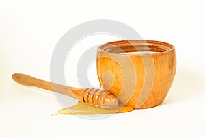 Honey in a wooden bowl with a special honey dipper.