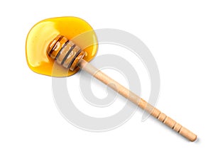 Honey with wooden honey dipper isolated on white background. Spilled honey. Honey Spoon, drizzler, stick photo