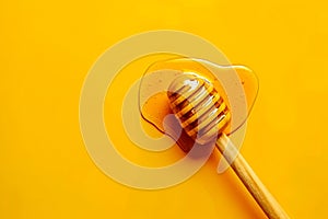 Honey on a wooden spoon on yelllow background photo
