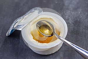 Honey Yogurt. Greek yogurt with honey in a plastic pot with honey and spoon