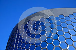 Honeycomb blue glass windows. Part of glazed facade of modern building. Office, shopping mall