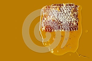 Honeycomb and flowing honey on a yellow background