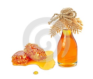 Honeycomb with honey bottle on white background