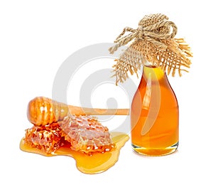 Honeycomb with honey bottle on white background