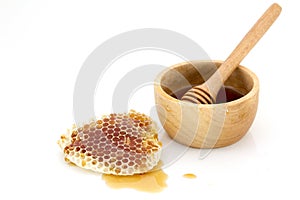 Honeycomb with honey dipper isolated on white background