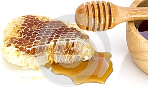 Honeycomb with honey dipper isolated on white background