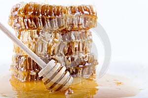 Honeycomb with honey and honey stick on white background