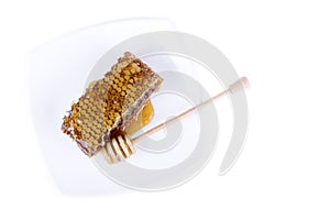 Honeycomb with honey and honey stick on white background