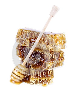 Honeycomb with honey and honey stick on white background