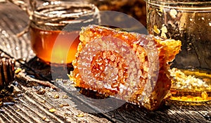 Honeycombs in closeup. Golden honeycomb on a wooden background. Sweet honey, pieces of combs and honey dipper