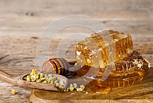 Honeycombs and honey spoon and dried chamomile flowers