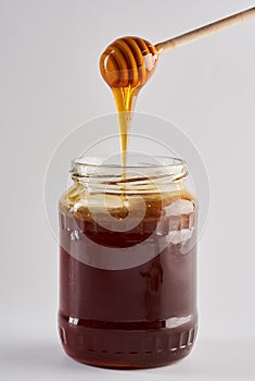 Honeydew honey in a jar with a dip stick