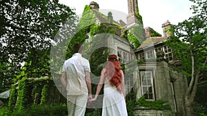 Honeymoon couple looking at beautiful country house. Fairytale house