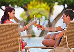 Honeymoon couple lying at sunbed near the blue ocean