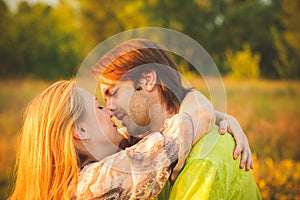 Honeymoon couple romantic in love at field and trees sunset. Newlywed happy young couple embracing enjoying nature