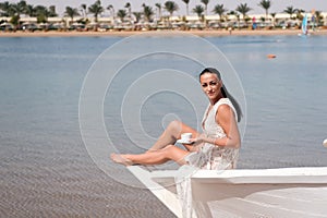 Honeymoon cruise ship. Wedding ceremony sea cruise. Bride adorable white wedding dress sunny day sit on boat or ship