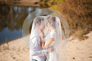 Honeymoon of just married wedding couple. happy bride, groom standing on beach, kissing, smiling, laughing, having fun on beach