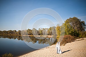 Honeymoon of just married wedding couple. happy bride, groom standing on beach, kissing, smiling, laughing, having fun on beach