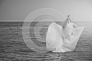 Honeymoon trip. Bride on sunny summer day on blue water