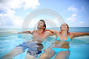 Honeymooners relaxing in swimming-pool